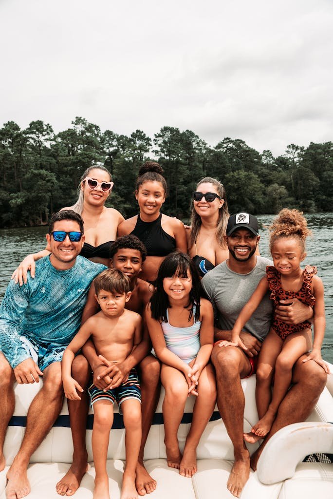 A joyful group of diverse family members smiling on a boat during summer in Houston, TX.