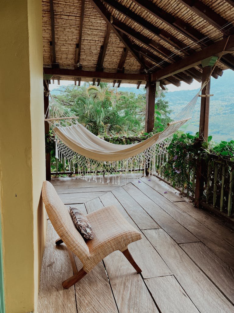 Relaxing tropical hammock and chair on a wooden porch in Medellín, Colombia.